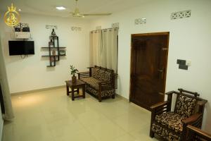 a living room with two chairs and a tv at T P Villas in Nilaveli