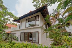 a house with large windows and trees at SEA TO SKY Villa - 4 Bedrooms Ocean View in Pulau Nongsa