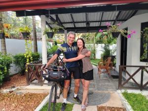 a man and a woman standing next to a bike at Villa Octopus in Maggona West