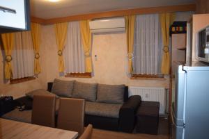 uma sala de estar com um sofá e cortinas amarelas em Apartment Borovnica em Moravske Toplice