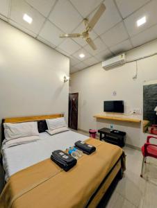 a bedroom with a bed with luggage on it at Hotel Rukmini Residency, Kolhapur in Kolhapur