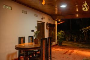 a dining room with a wooden table and chairs at T P Villas in Nilaveli