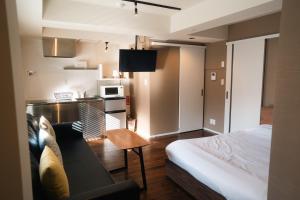 a room with a bed and a couch and a kitchen at Condominium MIRAHAKONE in Hakone