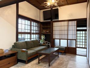 a living room with a couch and a table at Tasogare in Kihokucho
