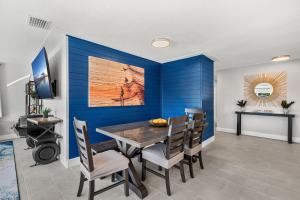 a dining room with blue walls and a table and chairs at 126 Deleon Rd in Cocoa Beach