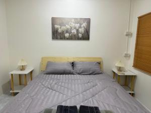 a bedroom with a bed with two nightstands and two lamps at Summer Sand in Haad Rin