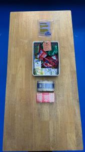 a container of candy on a table with books at First Avenue Male Hostel BSB in Bandar Seri Begawan