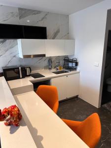 a kitchen with a table with orange chairs and a sink at Utopia Dream in Rawai Beach