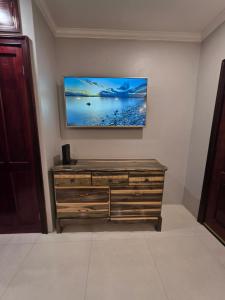 a flat screen tv on a wall above a dresser at Secret Hideaway in Ocho Rios