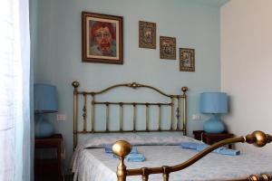 1 dormitorio con 1 cama, 2 lámparas y una pintura en Guesthouse Stazione Pisa Centro, en Pisa
