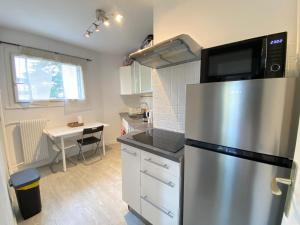 a kitchen with a stainless steel refrigerator with a microwave at Quiet Stay near Paris - Balcony & Private Parking in Châtillon +9 photos