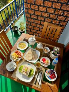 a table with plates of food on a balcony at Ella T&D Resort in Ella