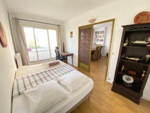 a bedroom with a large bed and a mirror at Quiet Stay near Paris - Balcony & Private Parking in Châtillon
