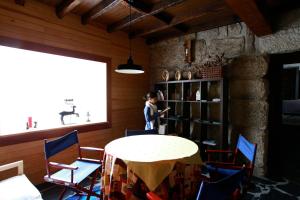 uma pessoa de p num quarto com uma mesa e cadeiras em Casa Ci em Vila Franca mais 34 fotografias