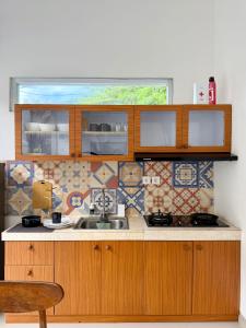 a kitchen with a sink and a tile wall at Villa Nala - Uluwatu Nusa Dua in Ungasan