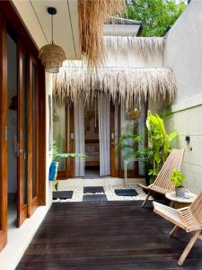 a porch with two chairs and a patio at Villa Nala - Uluwatu Nusa Dua in Ungasan