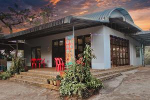 a small house with red chairs and a porch at Beyond Pub guest House and Hotel in Ban Tayun