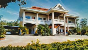 a large white house with a large driveway at Beyond Pub guest House and Hotel in Ban Tayun