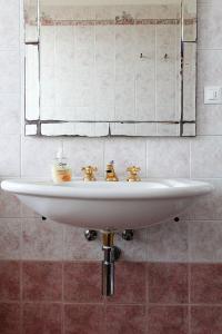 lavabo blanco en el baño con espejo en Guesthouse Stazione Pisa Centro, en Pisa