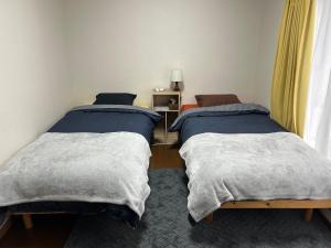 a bedroom with two beds and a window at KYOTO SHIMA in Kyoto