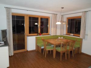 una cucina e una sala da pranzo con tavolo e sedie di Haus Panoramablick a Zellberg