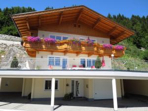 ein Gebäude mit einem Balkon mit Blumen darauf in der Unterkunft Haus Panoramablick in Zellberg