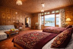 a bedroom with two beds and a view of the water at Mascot Houseboats in Srinagar