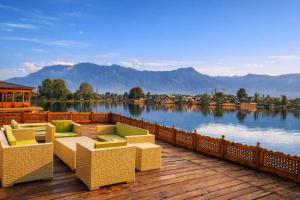 a deck with chairs and a view of a lake at Mascot Houseboats in Srinagar