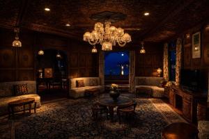 a living room with a chandelier and a table at Mascot Houseboats in Srinagar +30 photos