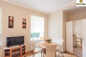 a dining room with a table and a television at Park Villa Apartments in Bad Kissingen