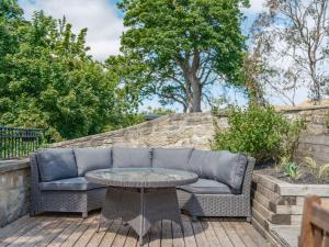 a couch and a table on a patio at Westhill House in Warkworth