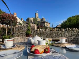 a table with a tea set with strawberries and bread at Westhill House in Warkworth