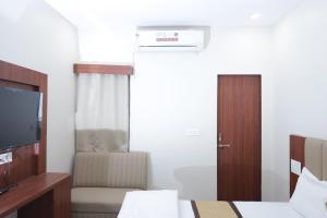 a hotel room with two beds and a television at The Gripa Hotels in Chitrakoot +36 photos