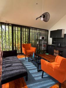 a living room with orange chairs and a table at Twenty ritz cottage in Migori