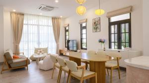 a dining room and living room with a table and chairs at Bơ Home Novaworld in Phan Thiet