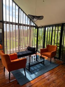 a living room with a couch and chairs and windows at Twenty ritz cottage in Migori +14 photos