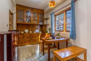a kitchen with wooden cabinets and a wooden table at Zeyul Homes in Manāli