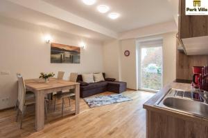a kitchen and living room with a table and a couch at Park Villa Apartments in Bad Kissingen