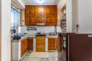 a kitchen with wooden cabinets and a refrigerator at Zeyul Homes in Manāli +77 photos