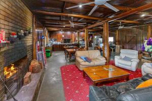 a living room with couches and a fireplace at Kin Kin Retreat in Quinninup