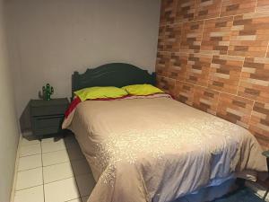 a bedroom with a bed and a brick wall at Casa Hostel Javi in Santiago +26 photos