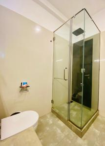 a bathroom with a toilet and a glass shower at Hotel Kandyan View ''Free pickup from Kandy city'' in Kandy +27 photos