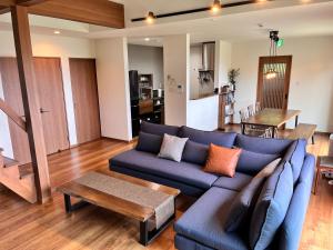a living room with a blue couch and a table at 山里の家 in Nanjo