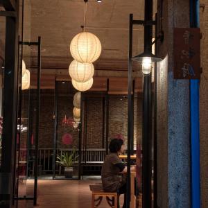 a woman sitting at a table in a building with lights at Limu Mountain Forest Park in Hainan