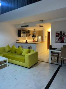a living room with a green couch and a kitchen at Saada in Tangier