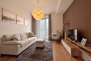 a living room with a couch and a tv at Charming & Cozy Ambiente Apartments in Bratislava