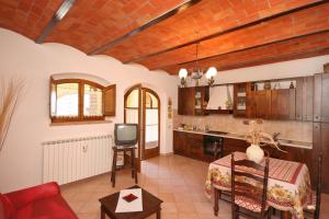 uma cozinha com uma mesa e uma televisão num quarto em Pienza by PosarelliVillas em Pienza