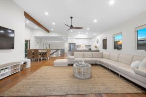 a living room with a couch and a table at Surfmist by the Beach Pet Friendly with Pool in Kingscliff