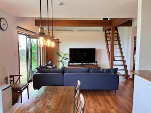 a living room with a blue couch and a tv at 山里の家 in Nanjo