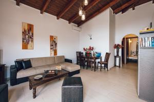 a living room with a couch and a table at Villa Andriana & Villa Elena - Beachfront Pool Villas in Vasilikos